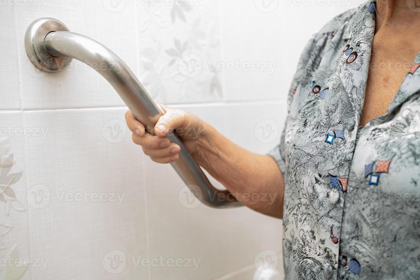 Une patiente asiatique âgée ou âgée utilise la sécurité de la poignée de la salle de bain des toilettes dans la salle d'hôpital de soins infirmiers, concept médical solide et sain. photo