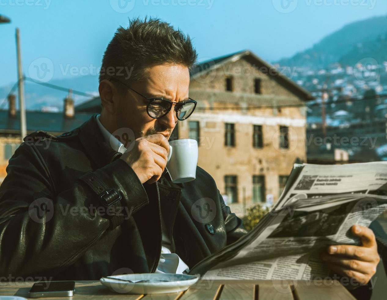 bel homme d'affaires adulte boit du café et lit le journal photo