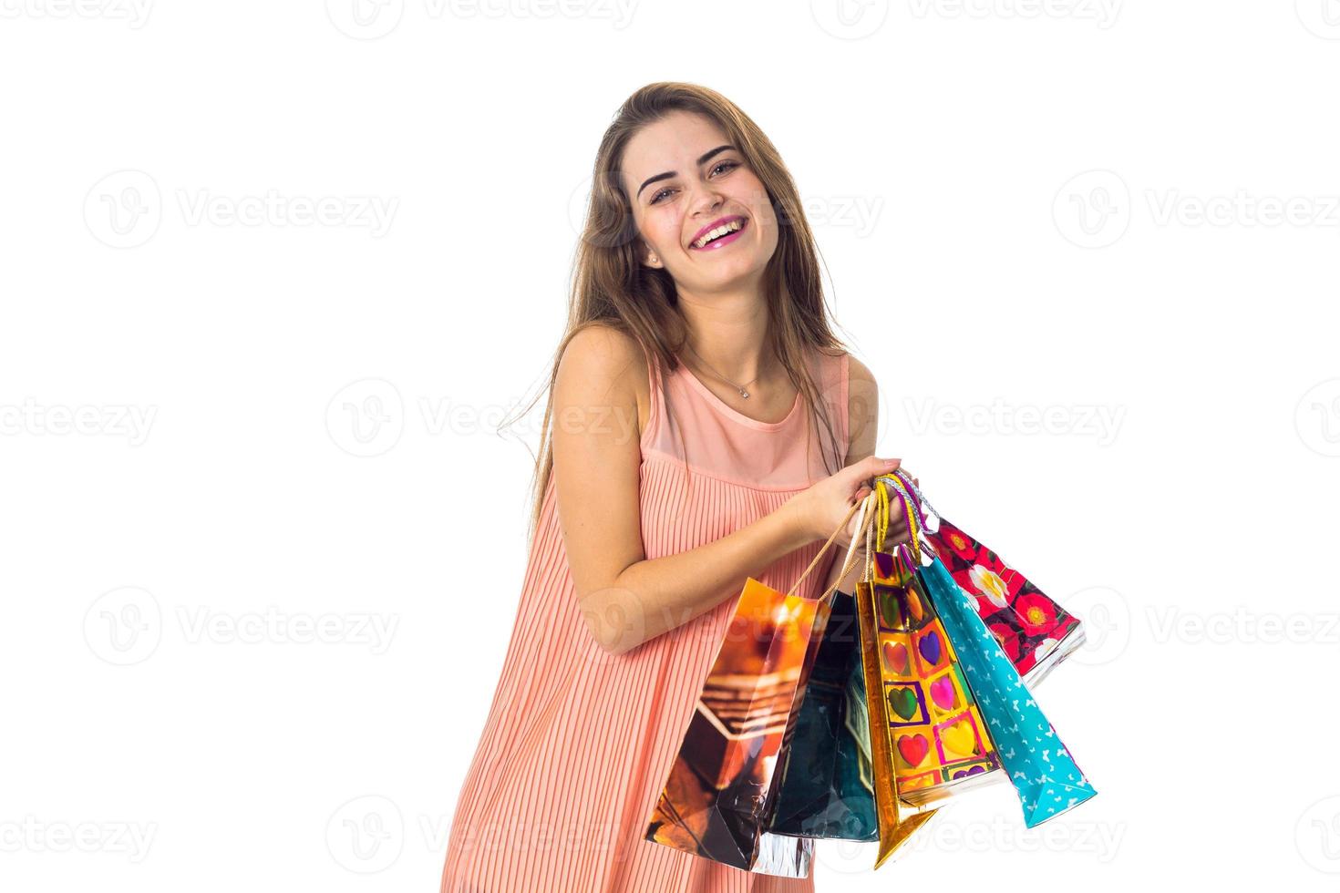 jeune fille rit et tient des sacs de couleurs vives isolés sur fond blanc photo