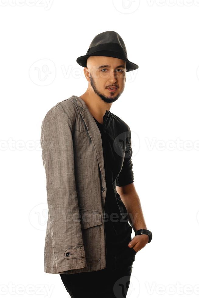 glamour jeune homme non rasé en chapeau et veste en regardant la caméra photo