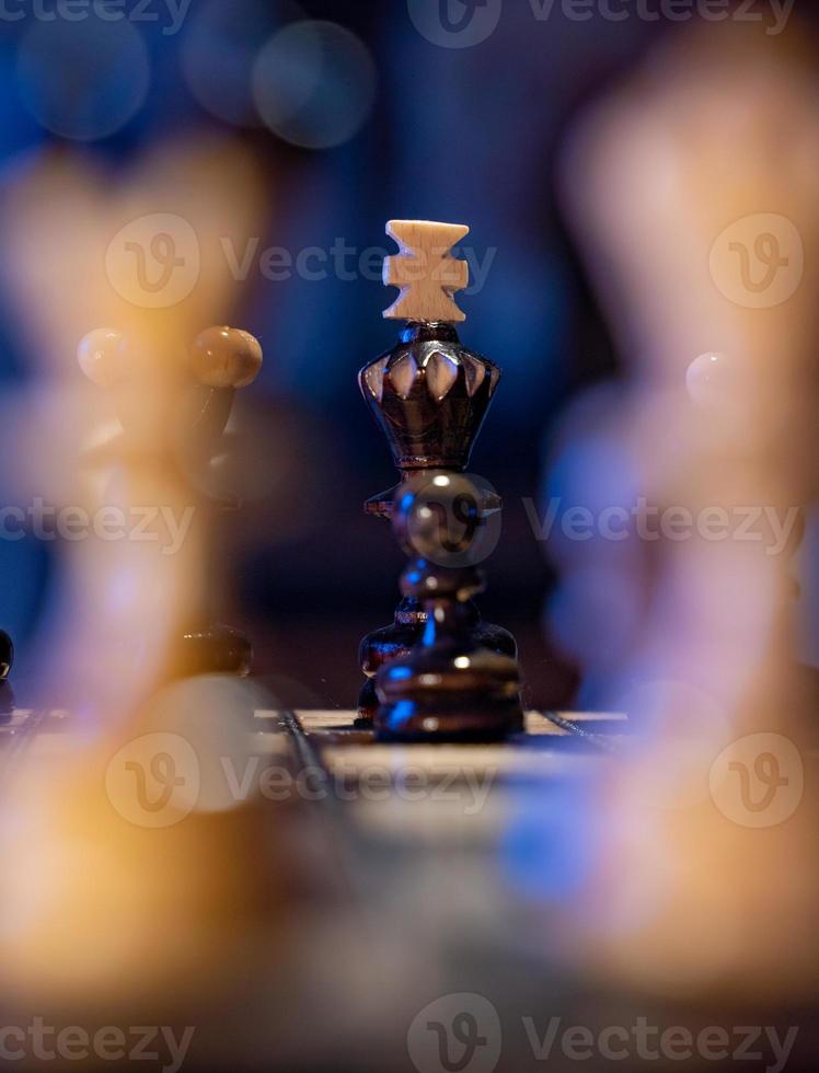 échiquier avec des pièces d'échecs sur fond bleu. concept d'idées commerciales et d'idées de concurrence et de stratégie. roi noir et figures se bouchent. photo