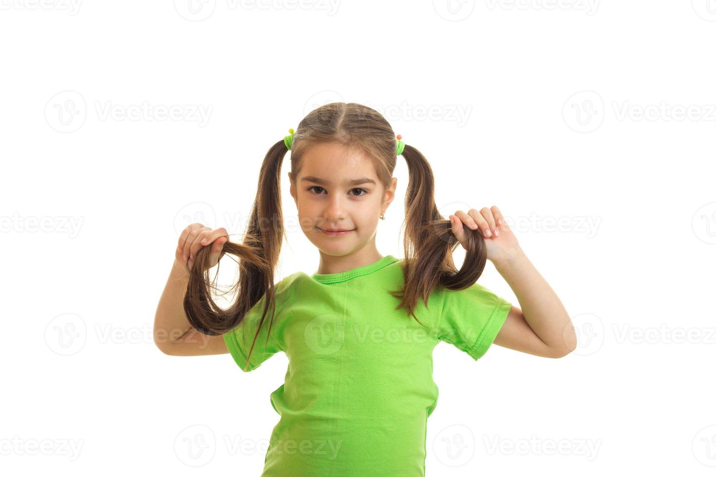 une merveilleuse petite fille avec des queues posant en studio photo