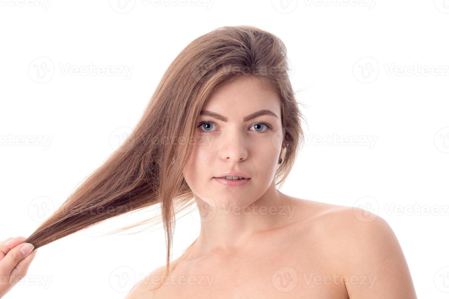 la jeune fille a l'air droite et garde les cheveux à la main photo