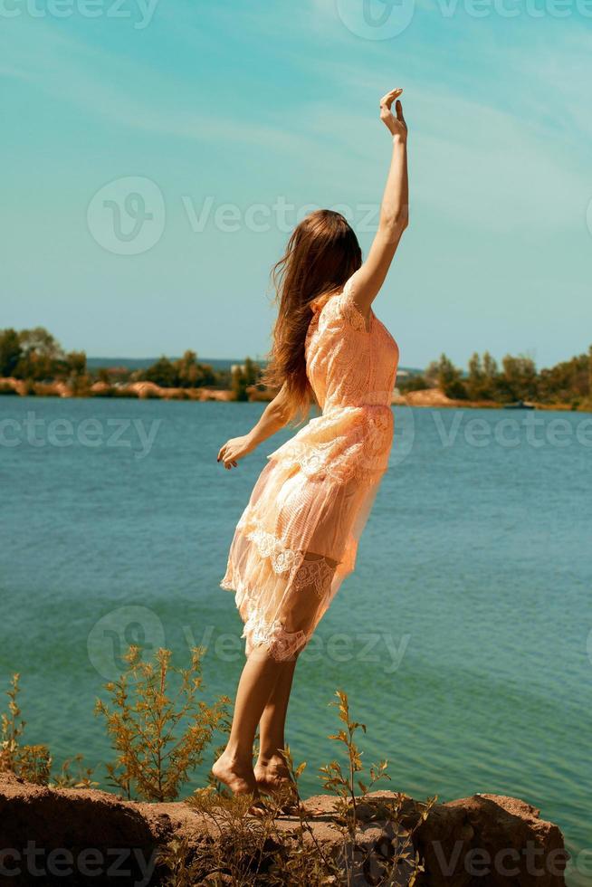 belle brune en robe rose sur la plage photo