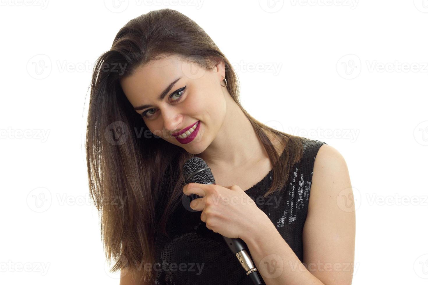 Cutie brunette girl with microphone sourit à la caméra photo