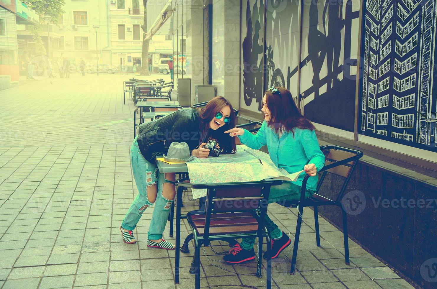 deux femmes assises à une table dans la rue photo