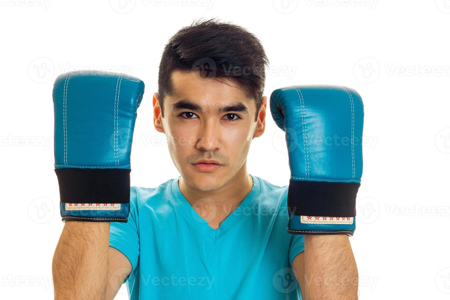 portrait de jeune homme pratiquant la boxe dans des gants bleus isolés sur fond blanc photo