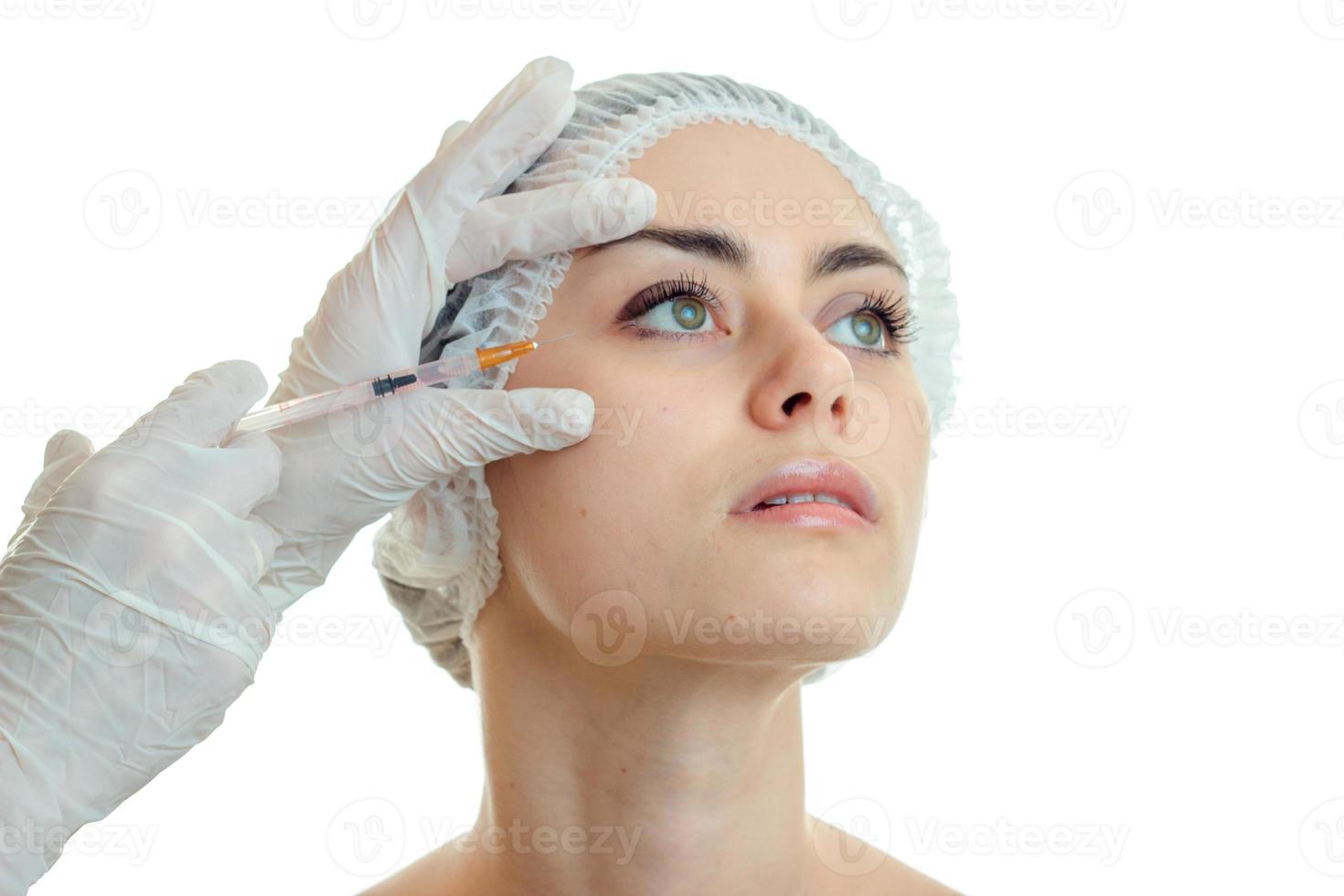 une jeune femme se fait piquer au visage par un médecin à la réception photo