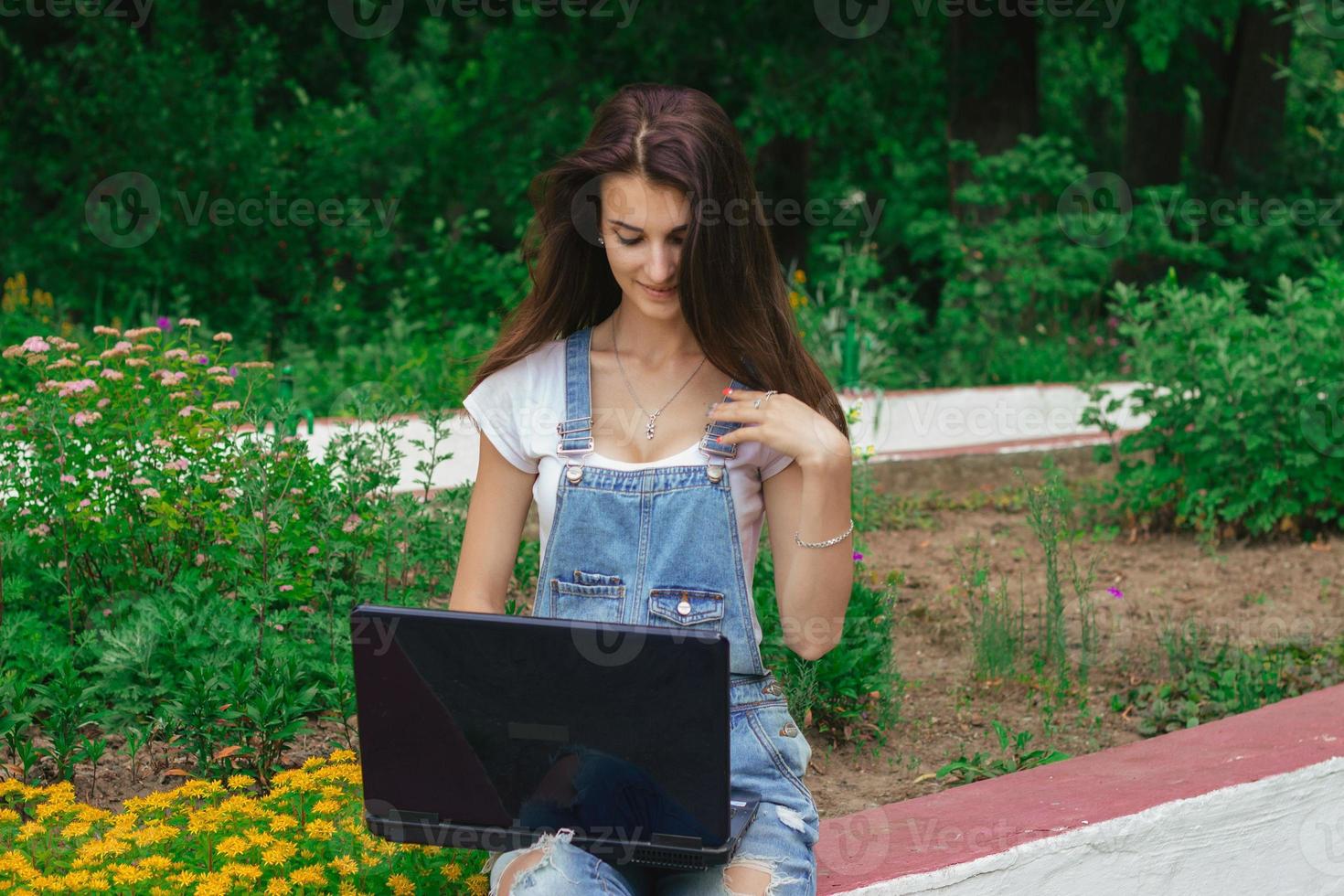 jolie jeune fille brune à l'aide d'un ordinateur portable photo