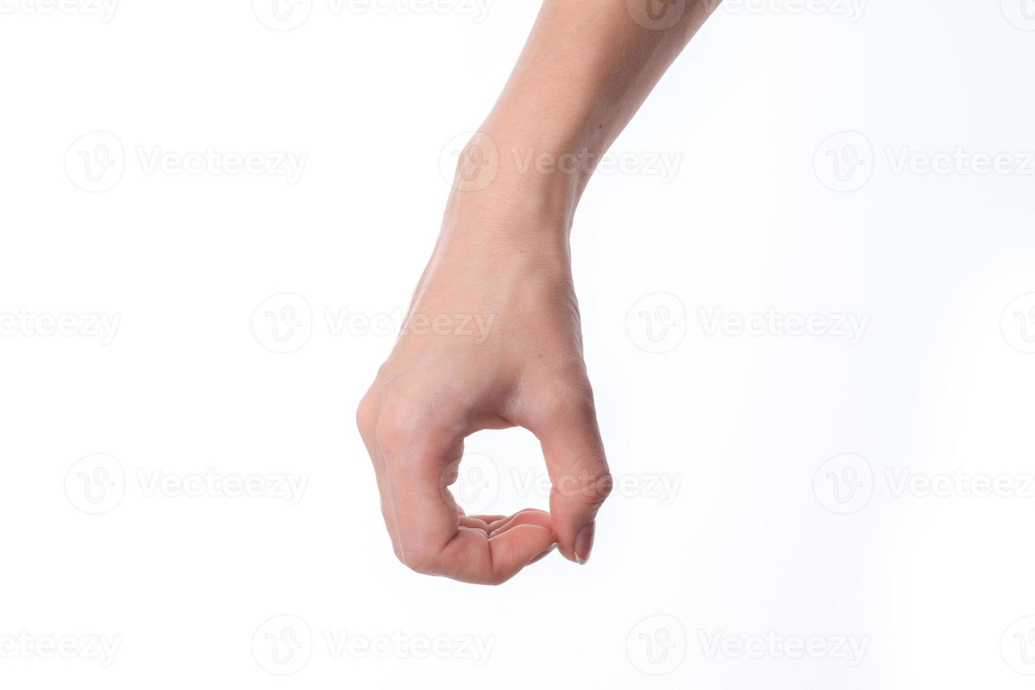 main féminine baissée et montrant le geste avec ses doigts joints en termes d'isolé sur fond blanc photo