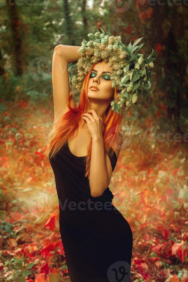 Dame mince sexuelle avec couronne de saut sur la tête en forêt posant photo