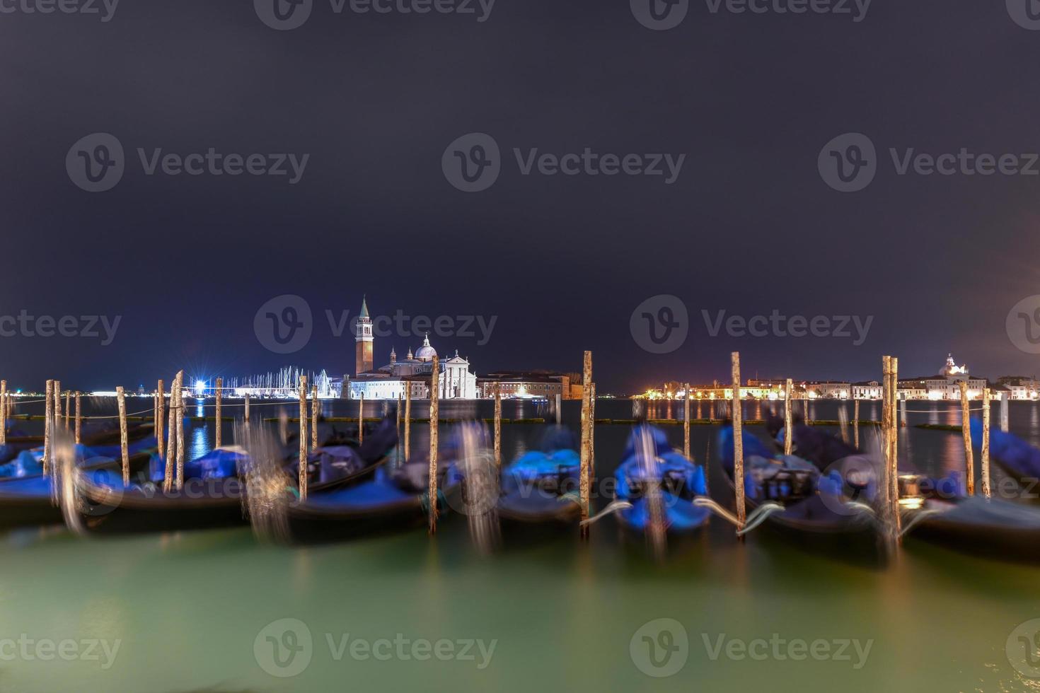 gondole flottant dans l'eau la nuit à venise, italie. photo