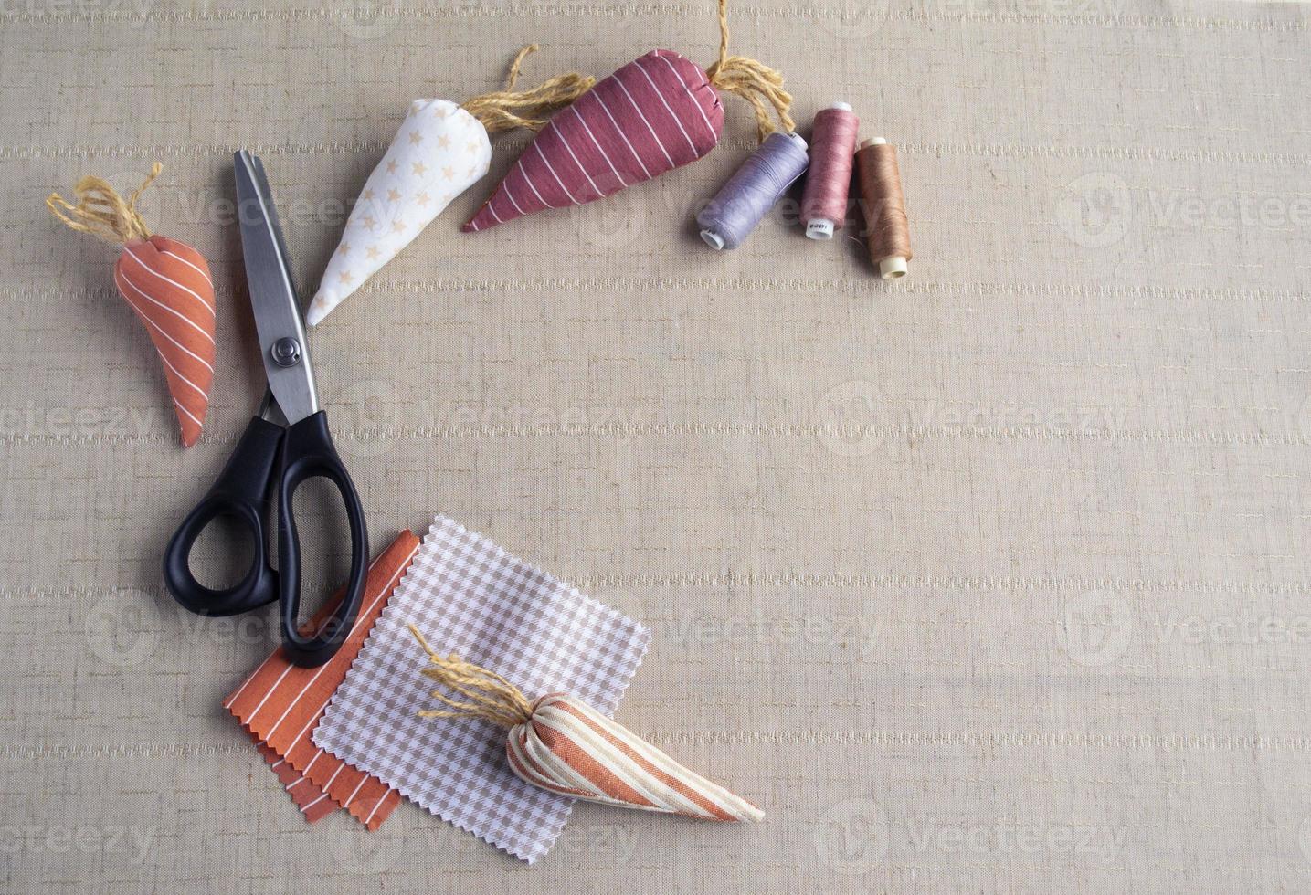 bannière de Pâques. carottes en tissu de coton, ciseaux et fil... décoration de Pâques. le concept de vacances, passe-temps, couture et travaux d'aiguille. photo