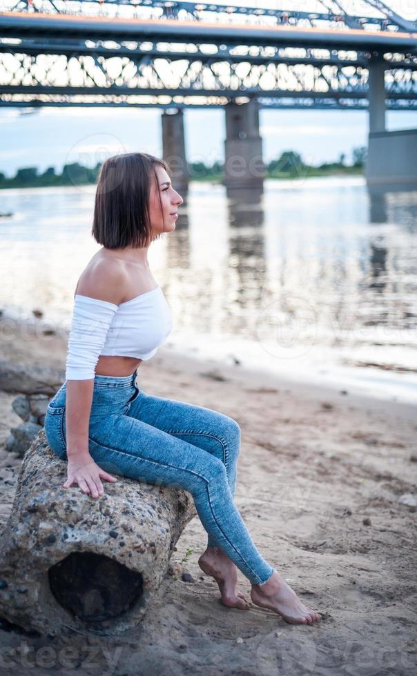 fille marchant sur la plage, contre le coucher du soleil. photo