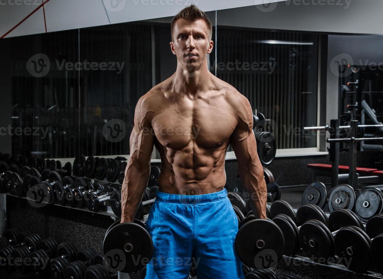 homme musclé pendant l'entraînement dans la salle de gym photo