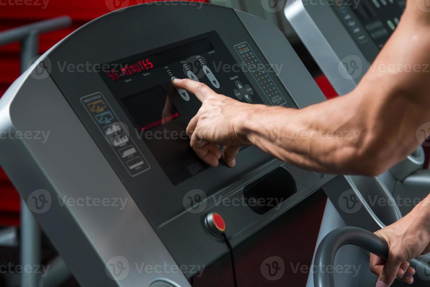 mains masculines sur le panneau de commande de la machine cardio photo