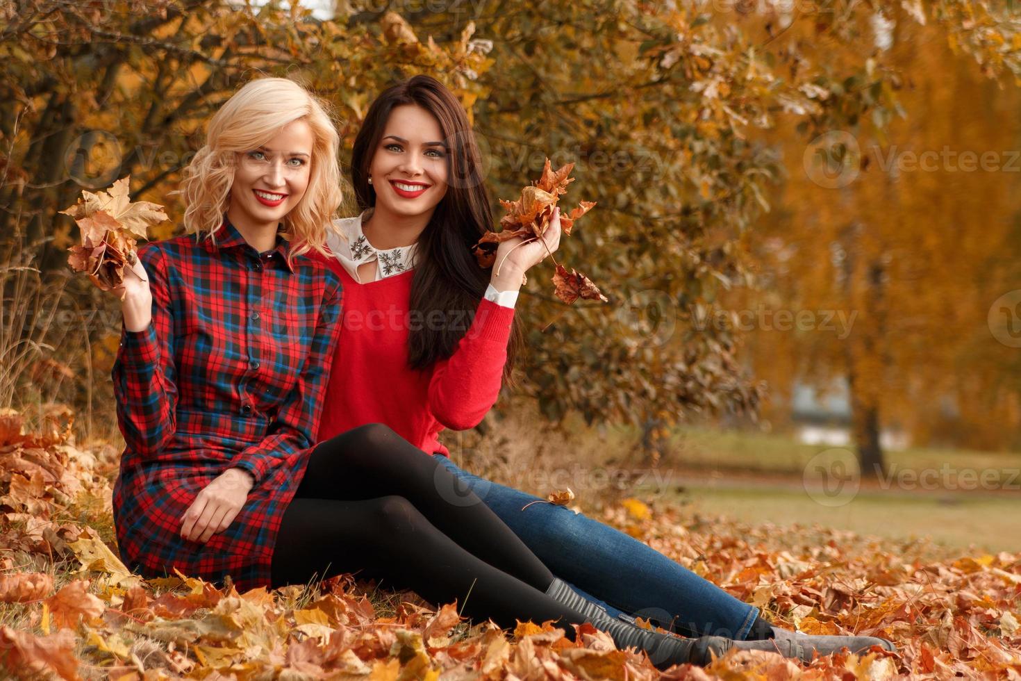 deux belles filles amies s'amusant dans le parc d'automne photo