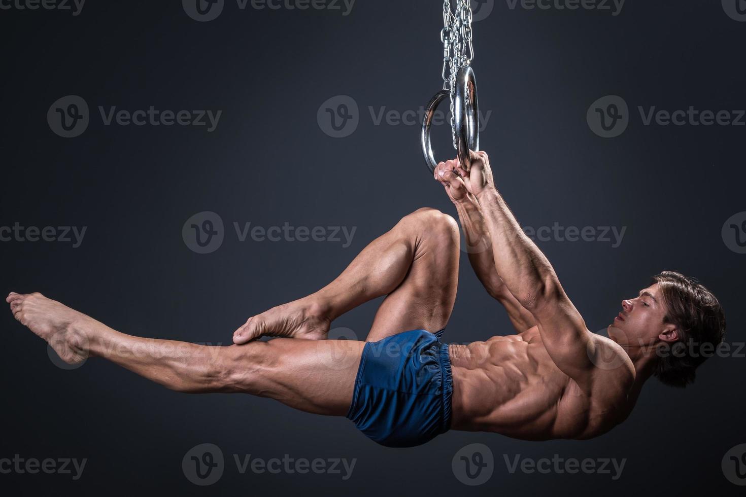 gars de gymnaste fort et musclé sur les anneaux photo