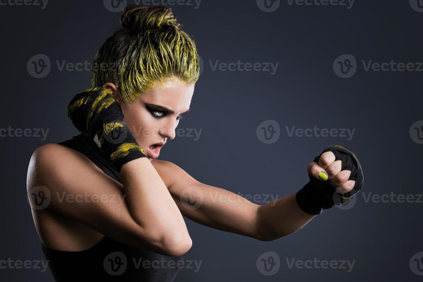 femme mma fighter aux cheveux jaunes en studio photo