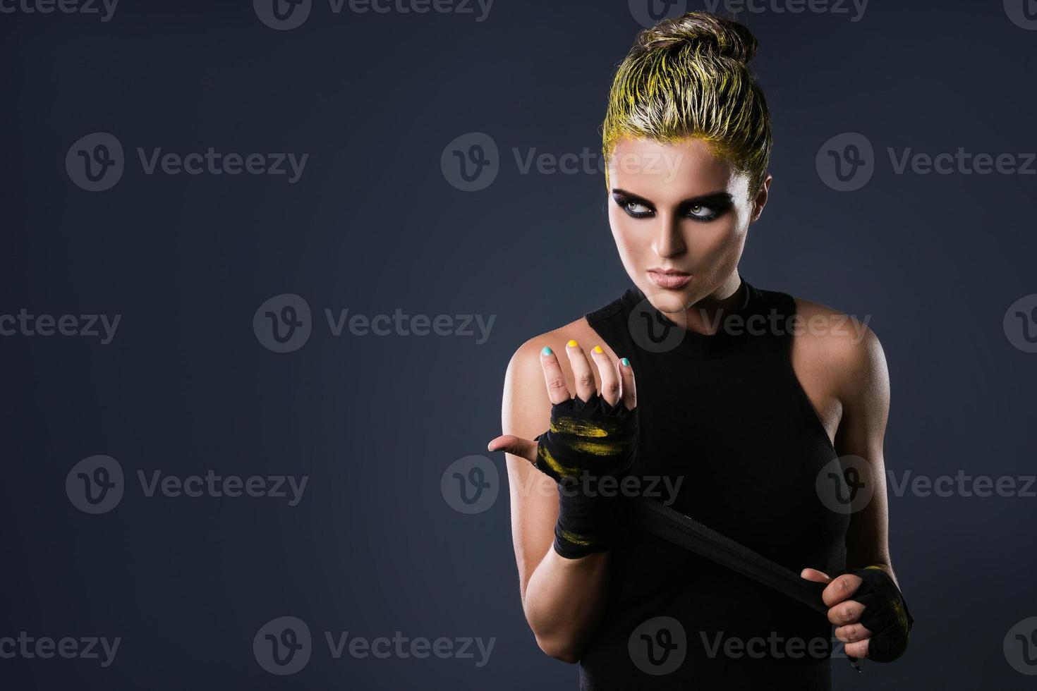 femme mma fighter aux cheveux jaunes en studio photo