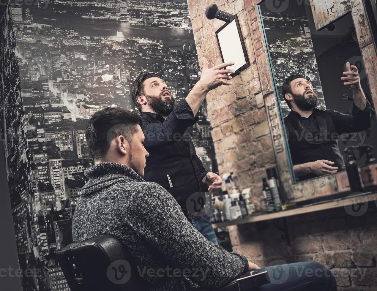 barbier pendant son travail avec le client dans son studio photo