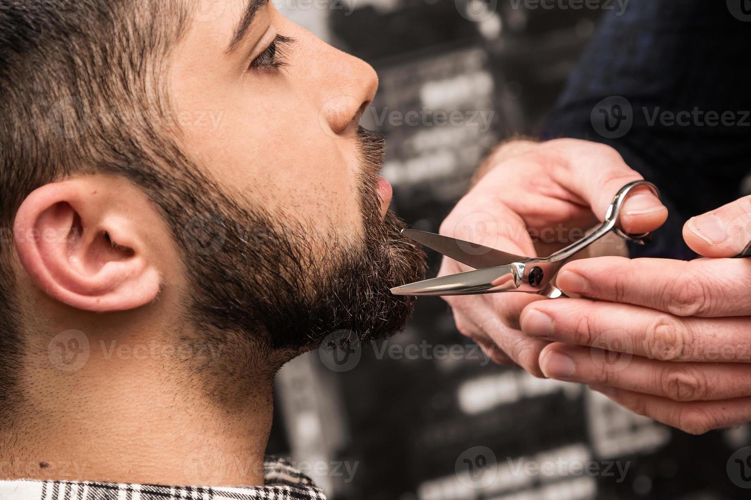 le coiffeur travaille avec des ciseaux dans son salon photo