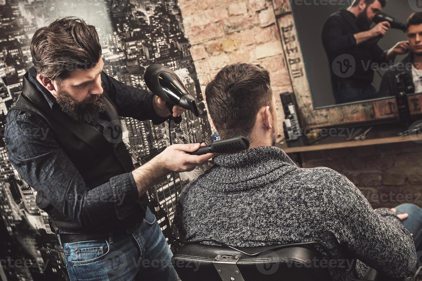 coiffeur pendant le travail avec un client dans le salon de coiffure photo