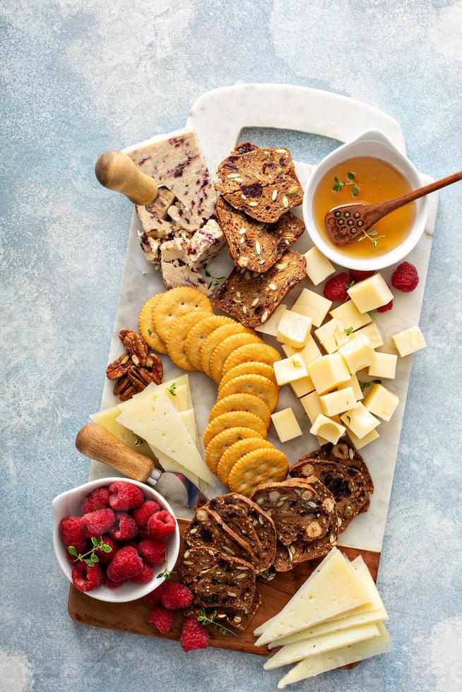 plateau de fromages et snacks avec framboise et craquelins photo