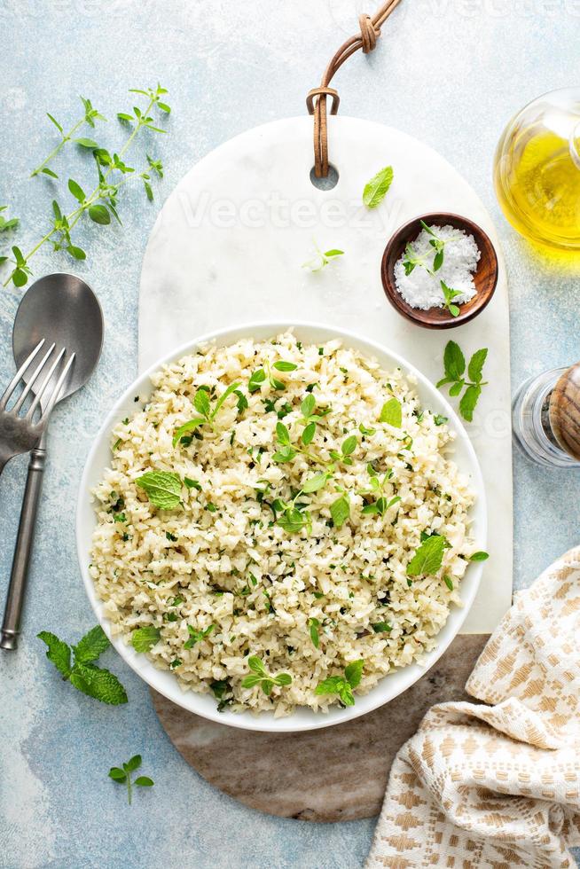 riz de chou-fleur aux herbes et jus de citron dans un bol blanc photo