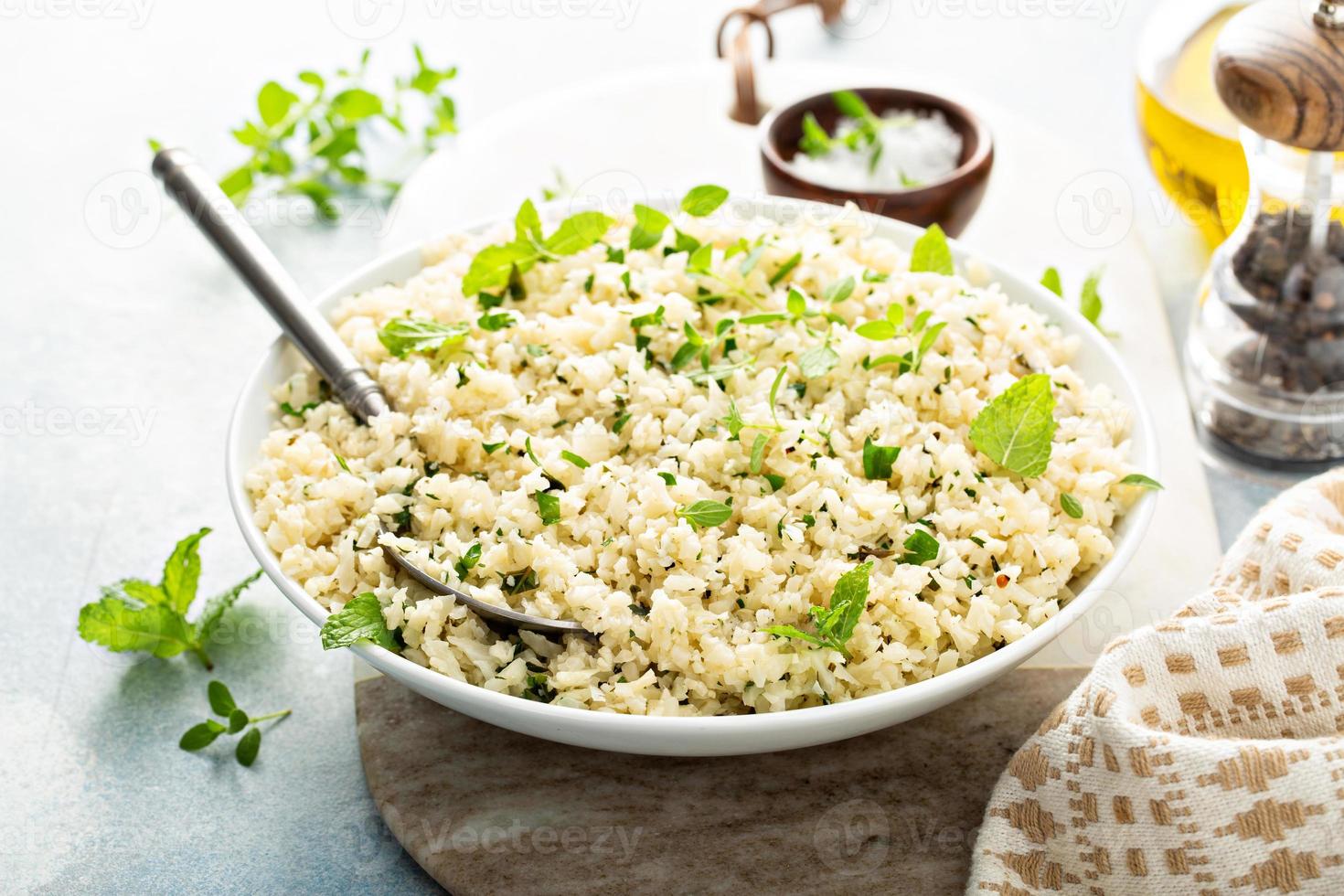 riz de chou-fleur aux herbes et jus de citron dans un bol blanc photo