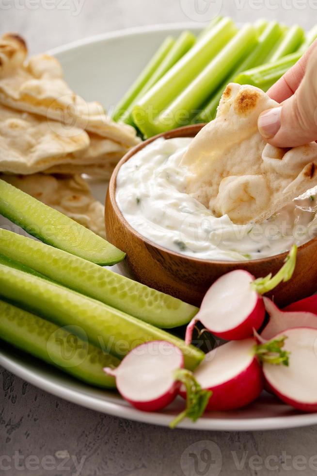 grande planche à collation avec trempette ou sauce tzatziki et légumes frais photo