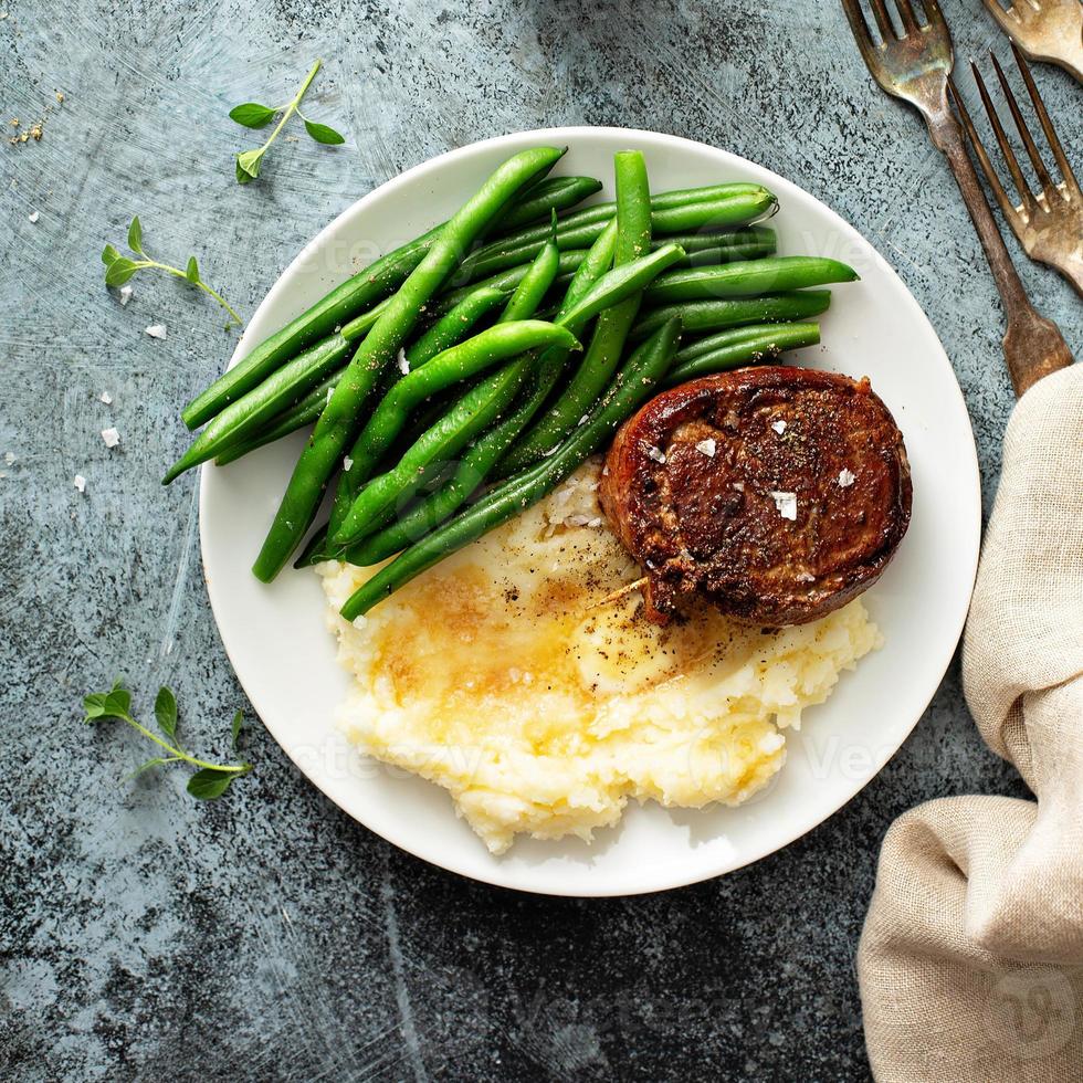 dîner traditionnel avec un steak enveloppé de bacon et des pommes de terre photo