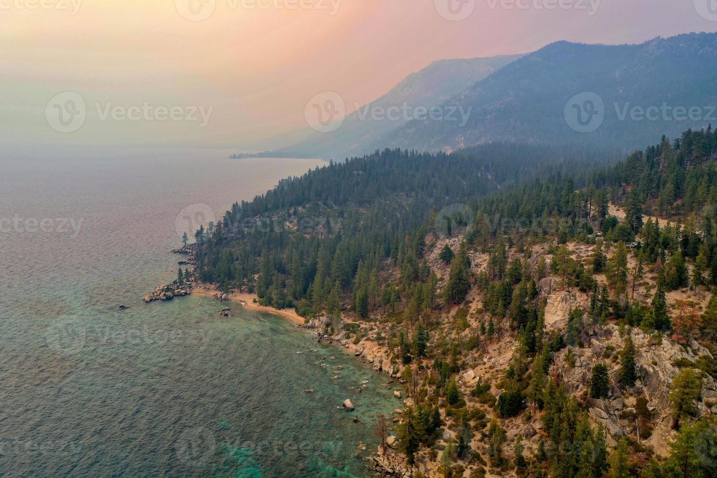 crique secrète le long du lac tahoe au nevada avec un ciel brumeux en raison des incendies de forêt à proximité en californie. photo