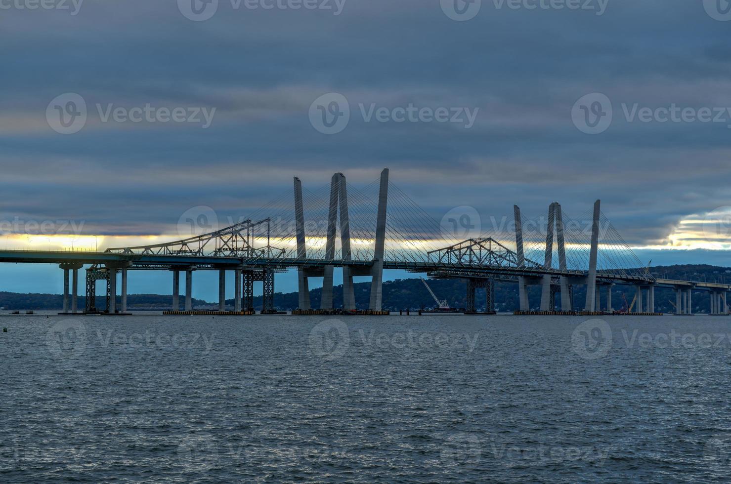 nouveaux et anciens ponts tappan zee coexistant sur la rivière hudson avec un coucher de soleil spectaculaire. photo