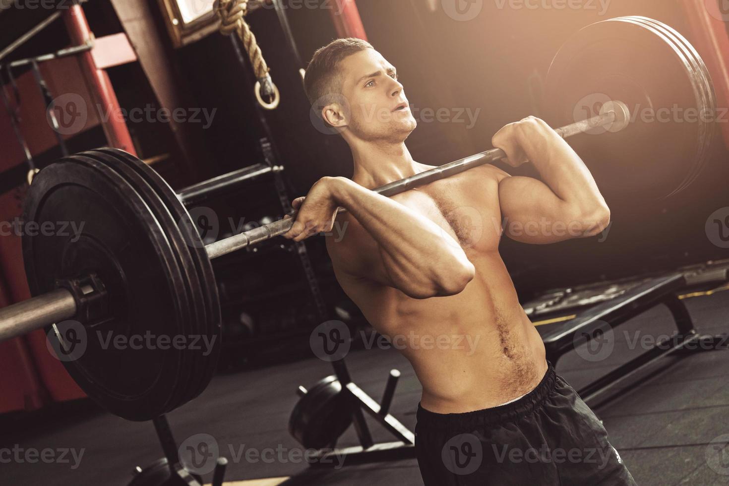 homme musclé pendant son entraînement d'haltérophilie dans la salle de gym photo