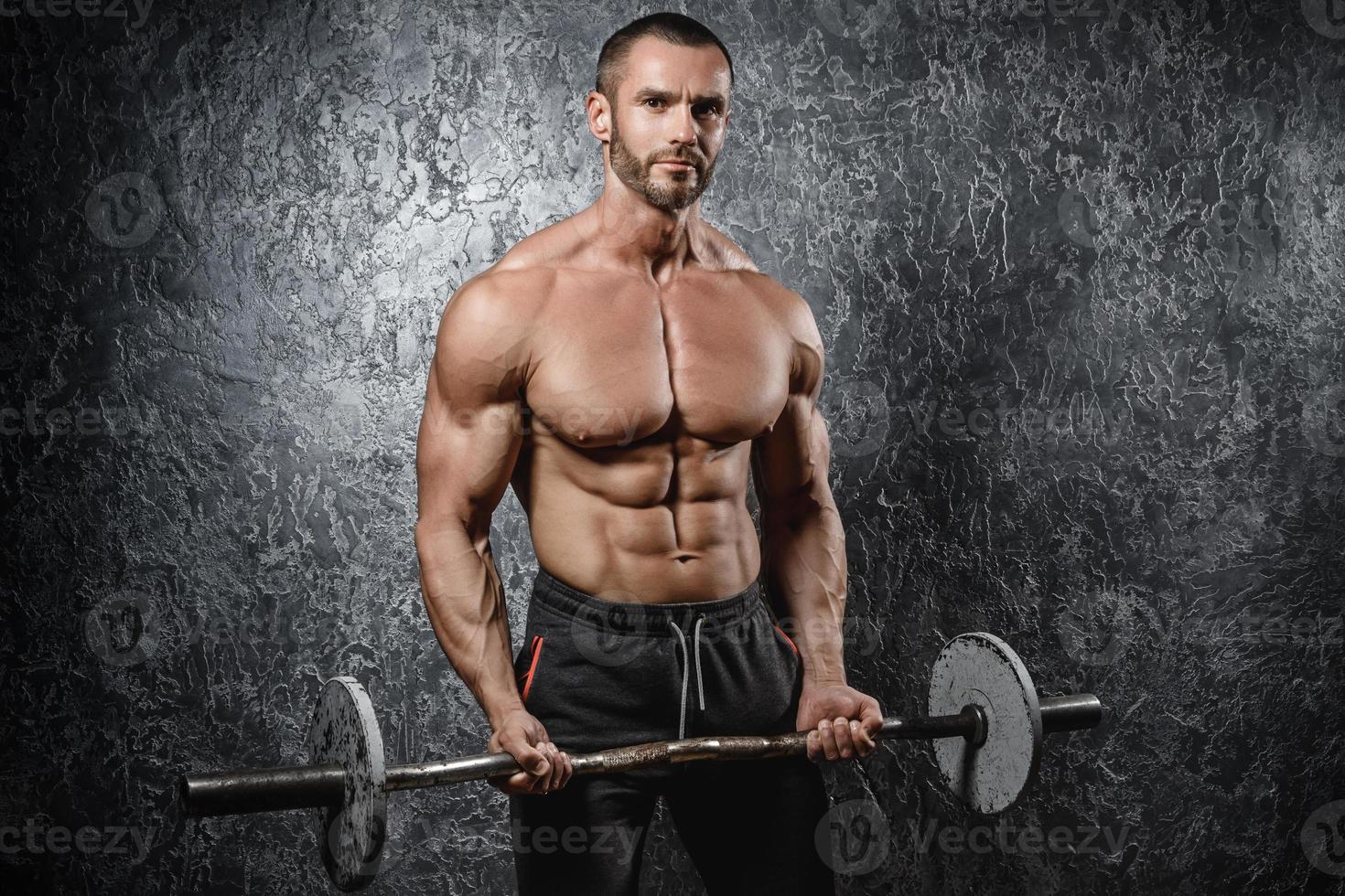 beau bodybuilder musclé faisant de l'exercice avec une barre photo