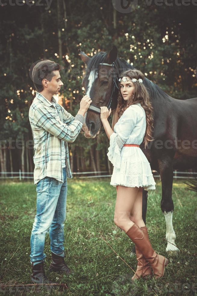 jeune couple prenant soin de beau cheval photo