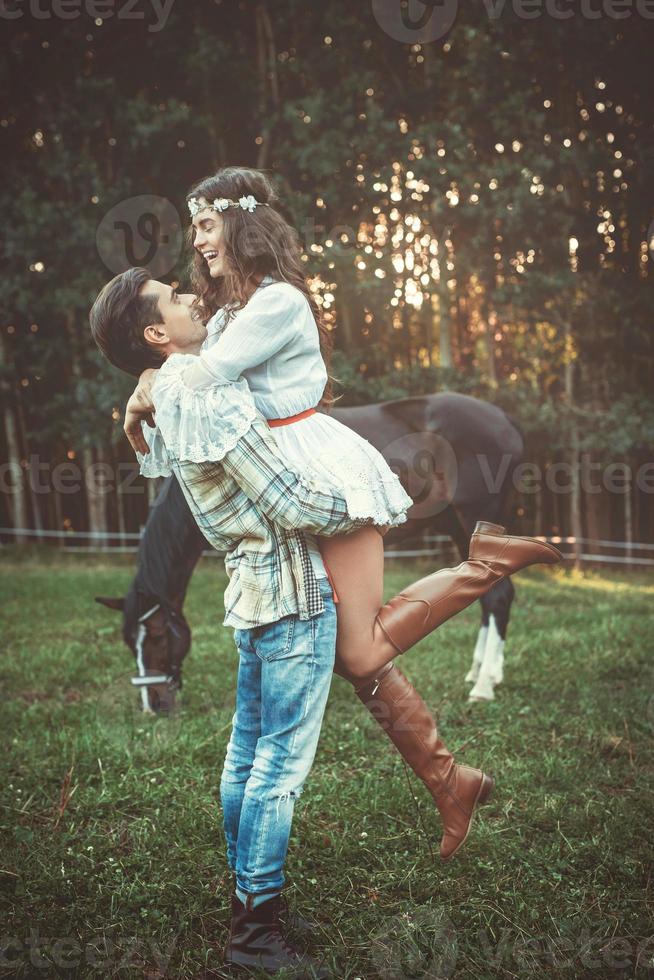 jeune couple dans une étreinte sur le pré avec un cheval photo