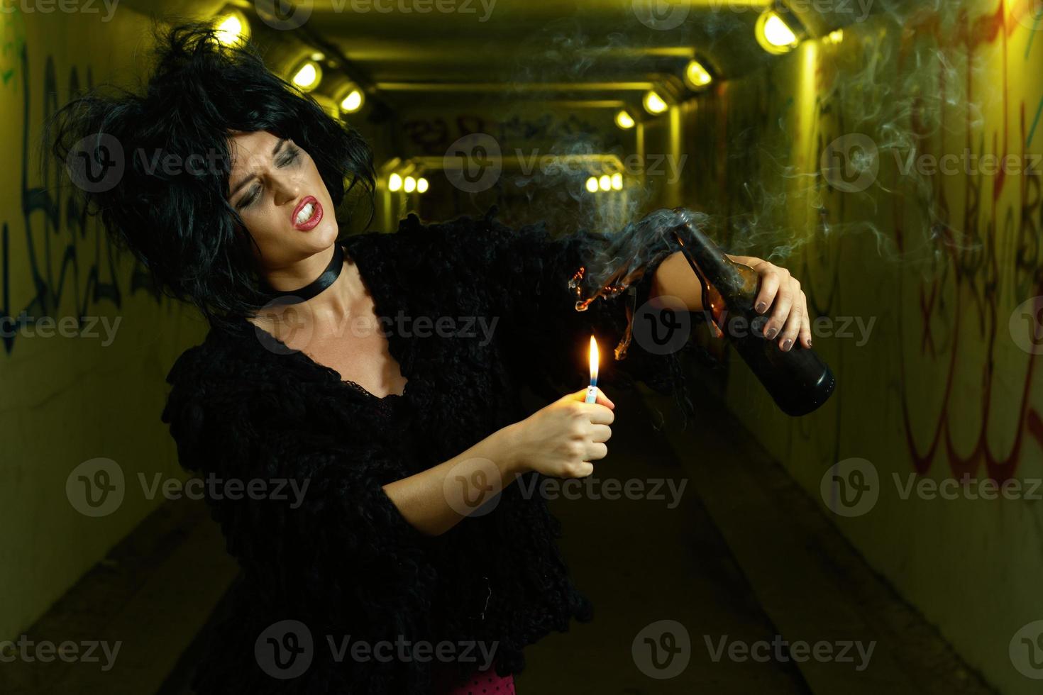 femme bizarre dans un tunnel sombre avec une bouteille piégée photo