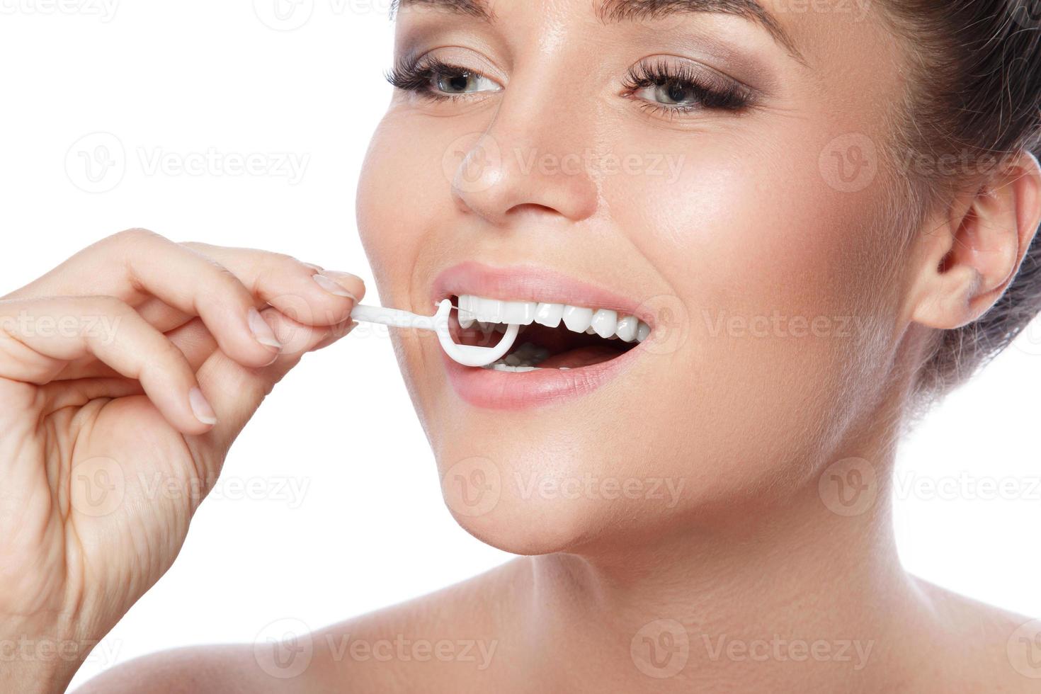 femme avec du fil dentaire choisir sur fond blanc photo