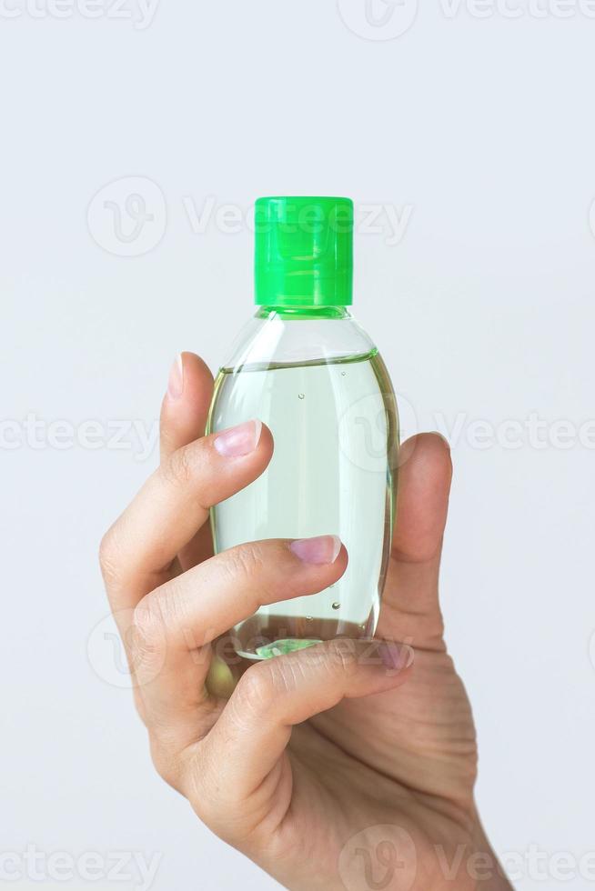 main avec une petite bouteille de désinfectant pour les mains photo