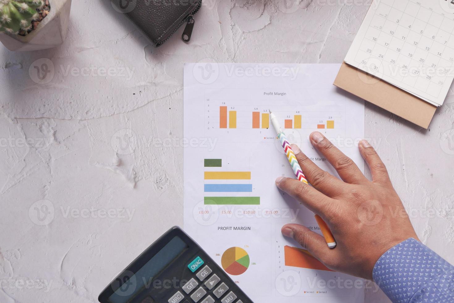 main de l'homme avec un stylo analysant un graphique à barres sur papier photo