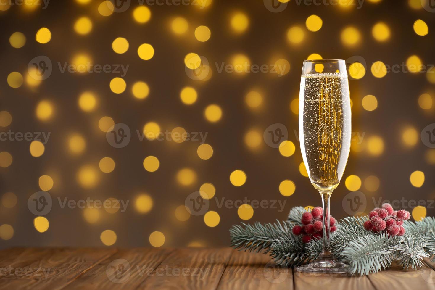 verre à vin avec champagne pétillant sur fond de lumières scintillantes floues photo