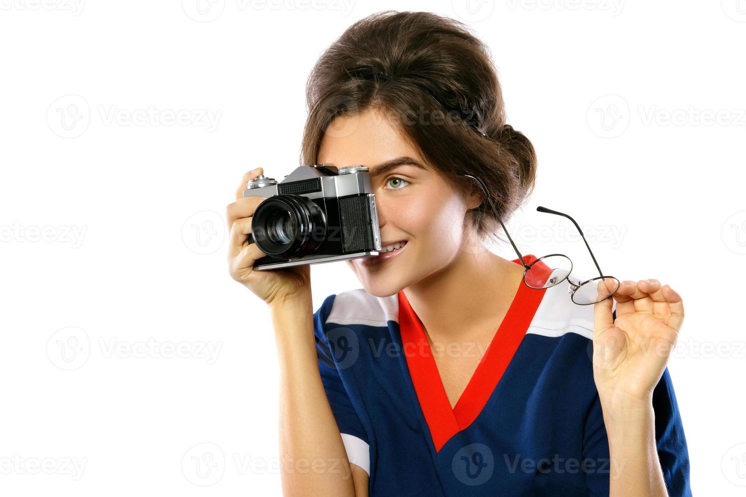 modèle femme au look vintage tenant un appareil photo rétro dans ses mains