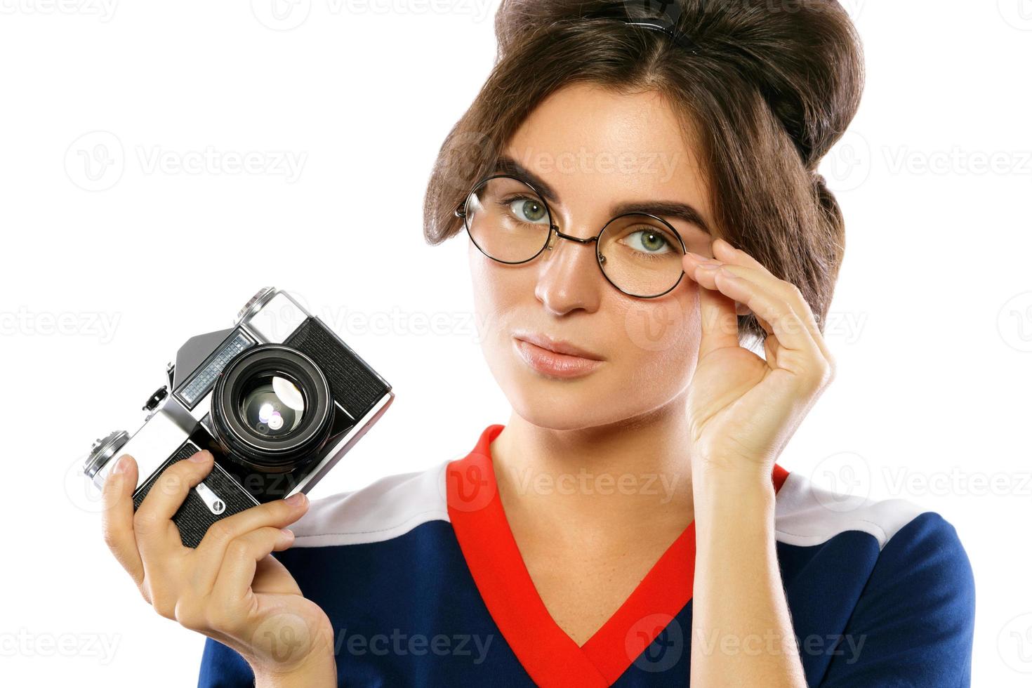 modèle femme au look vintage tenant un appareil photo rétro dans ses mains