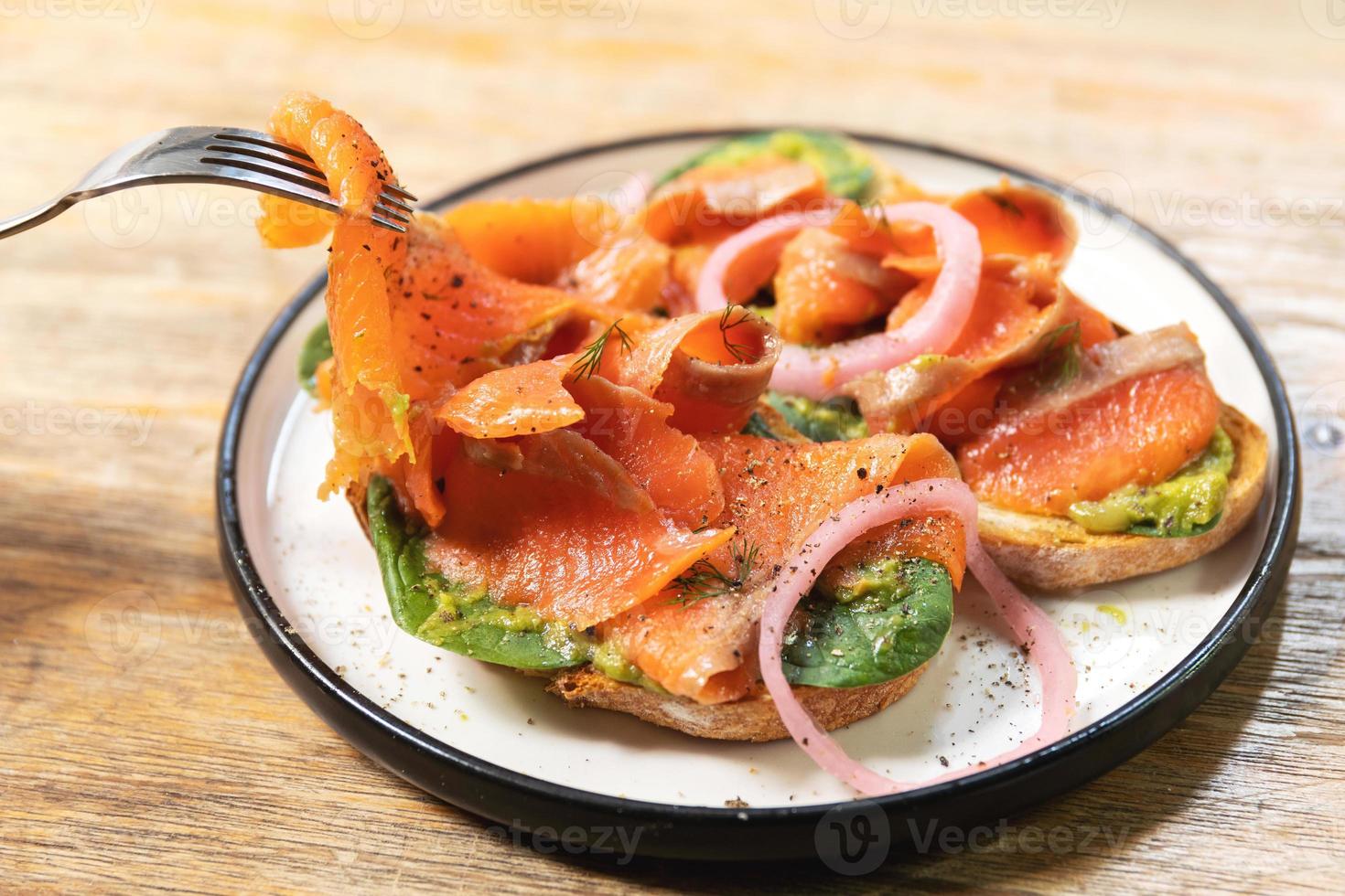 délicieux toasts au saumon fumé, avocat et feuilles de basilic photo