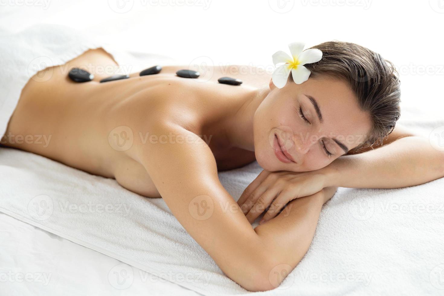 jeune et belle femme pendant le massage aux pierres chaudes photo