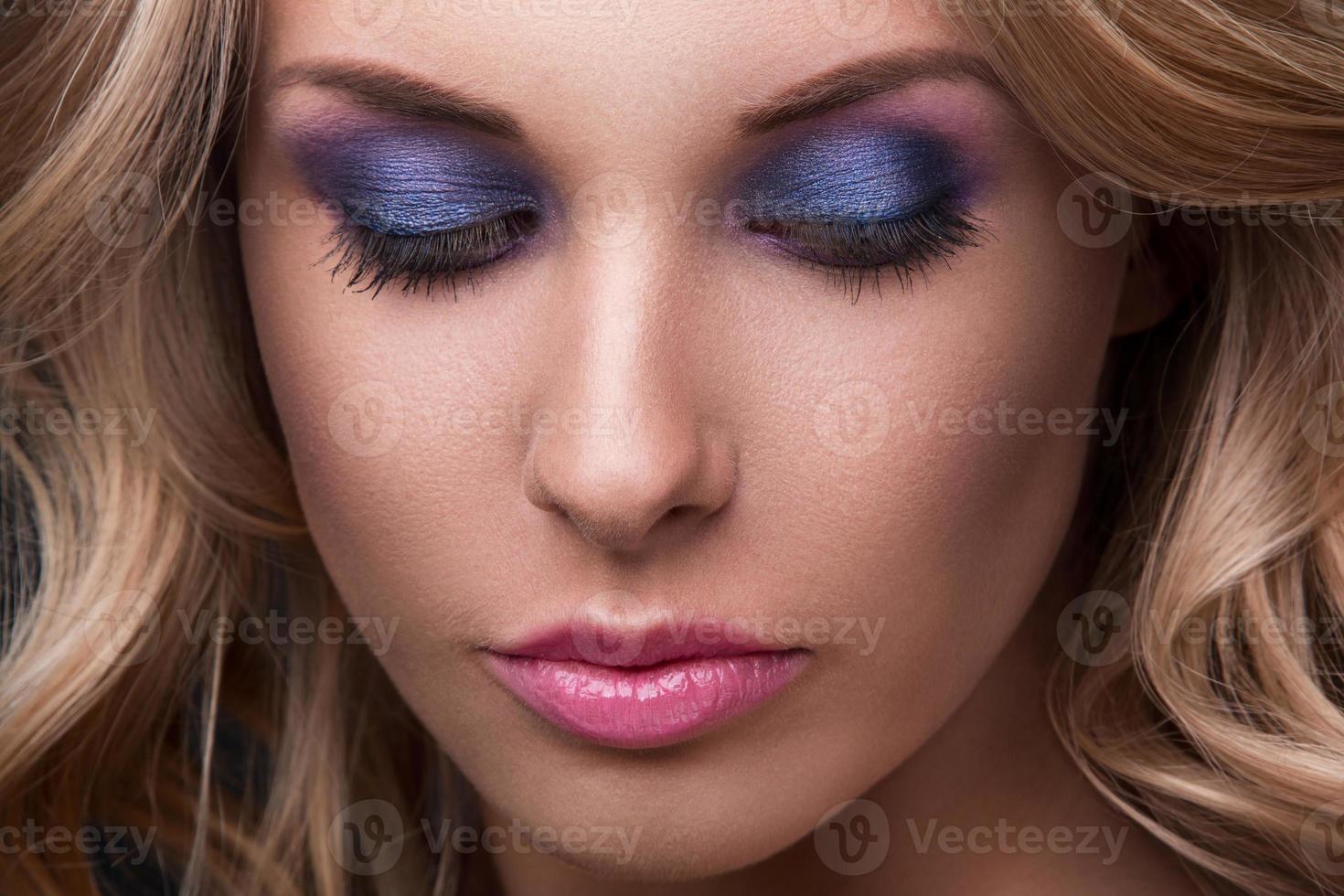 femme blonde aux cheveux ondulés et maquillage coloré photo