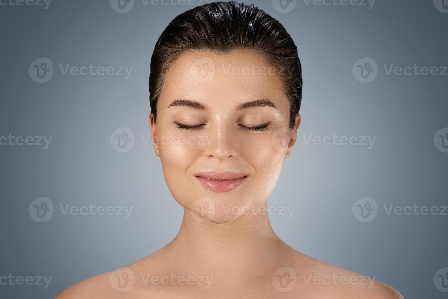 belle jeune femme avec une peau parfaite sur fond gris photo