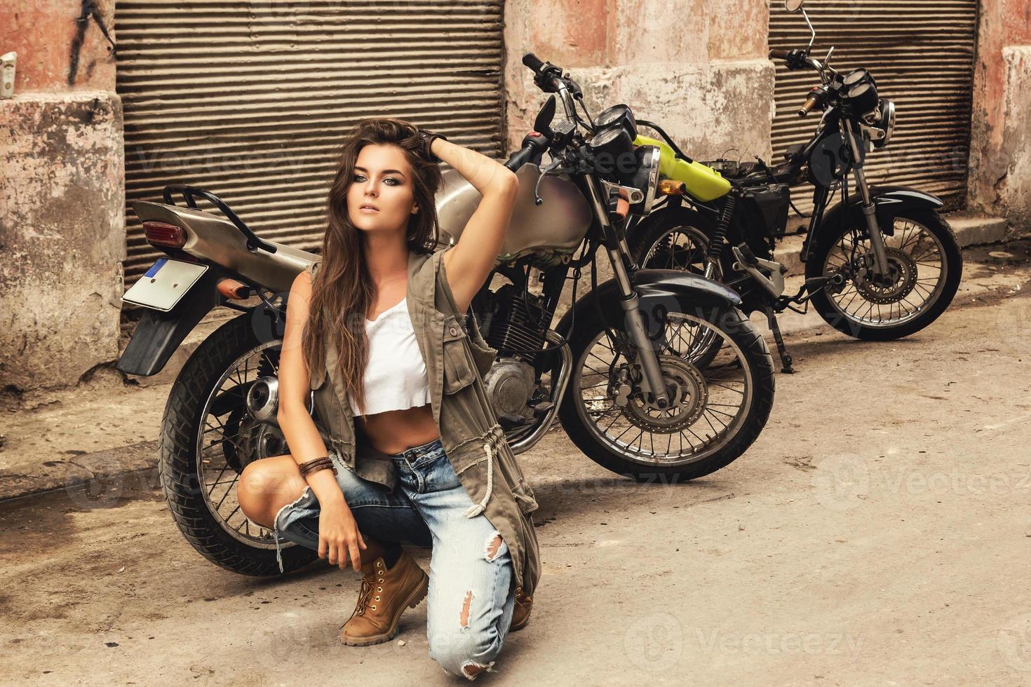 modèle femme pose à côté de vieilles motos photo